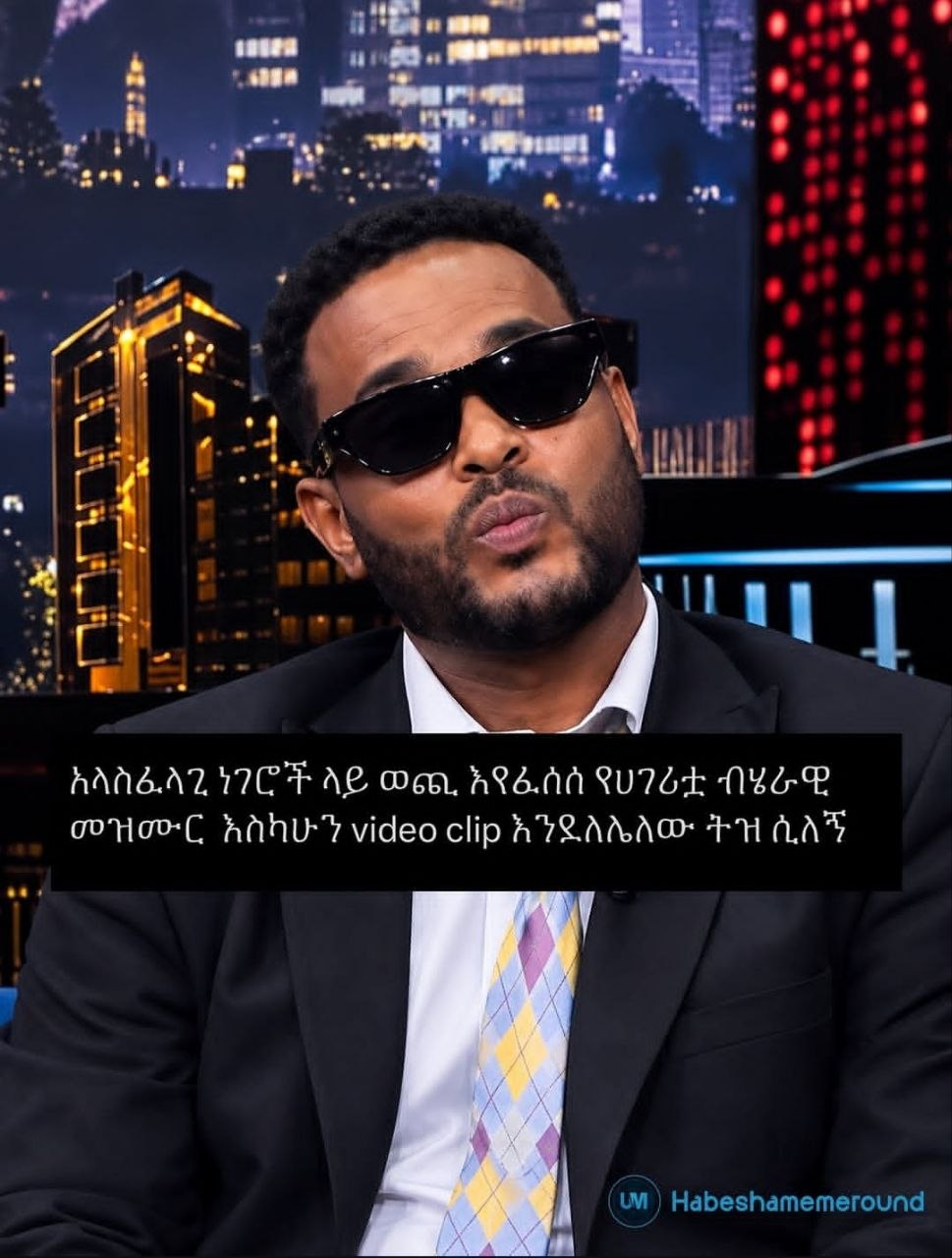 a man in a suit and sunglasses sitting on a couch